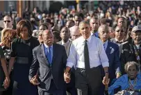  ?? Saul Loeb / Getty Images ?? Lewis walks between Michelle Obama and President Barack Obama on the 50th anniversar­y of the Alabama march.