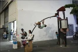  ?? ARIANA CUBILLOS — THE ASSOCIATED PRESS ?? Children play on a jungle gym along Sabana Grande boulevard in Caracas, Venezuela, on Wednesday.