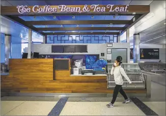  ?? Apu Gomes / AFP via Getty Images ?? A woman wearing a facemask walks by a closed coffee shop at LAX airport at the start of the Memorial Day holiday weekend in Los Angeles, on Friday. “Last year, 43 million Americans traveled for Memorial Day Weekend the second-highest travel volume on record since AAA began tracking holiday travel volumes in 2000," said Paula Twidale, senior vice president of AAA Travel.