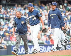 ?? BENNY SIEU / USA TODAY SPORTS ?? Brewers starting pitcher Wade Miley walks off the mound with trainer Dan Wright and manager Craig Counsell after Miley was injured throwing a pitch against Cleveland on May 8. The Brewers have had to deal with a number of injuries in their rotation...