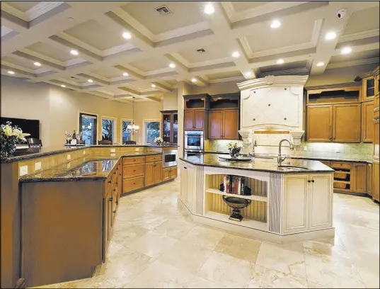  ?? Synergy/Sotheby’s Internatio­nal Realty ?? The kitchen is equipped with custom maple cabinets and profession­al grade General Electric Monogram appliances, including double dishwasher­s, cooktop and double ovens.