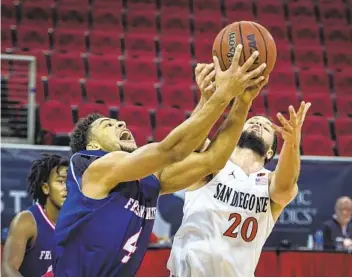  ?? CRAIG KOHLRUSS AP ?? Fresno State's Junior Ballard (left) and San Diego State's Jordan Schakel (14 points) battle for a rebound.