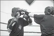  ?? The Washington Post/JABIN BOTSFORD ?? Women cadets trade punches during boxing class at the U.S. Military Academy. “At first I was kind of upset, but now I’m getting into it,” one female cadet said.