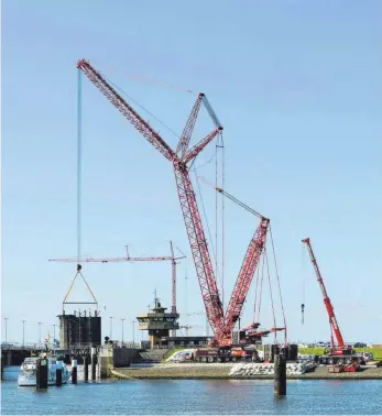  ?? FOTO: LIEBHERR ?? Imposantes Kraftpaket: Der Ehinger Kran LG 1750 hat das erste der sechs Schleusent­ore des Sperrwerks in Büsum am Haken.