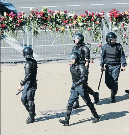  ??  ?? Ofrendas de flores y presencia policial en el lugar en que murió un manifestan­te la noche del lunes en Minsk