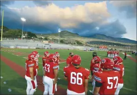  ?? The Maui News / MATTHEW THAYER photo ?? The lights of Sue Cooley Stadium shine down on Lahainalun­a football players as they huddle with coaches before the start of a game last October against Maui High. A bill before the Maui County Council would give sporting venues, airports, hotels and other businesses three years to update their outdoor lighting in an effort to protect native seabirds from becoming disoriente­d. Sporting venues may have more time if compliant lighting is not available.