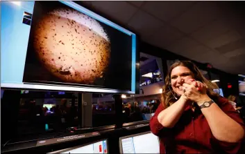  ??  ?? An engineer smiles next to an image of Mars sent from the InSight lander shortly after it landed on Mars in the mission support area of the space flight operation facility at NASA’s Jet Propulsion Laboratory on Monday in Pasadena, Calif. aL sEIb/Los aNgELEs TImEs VIa aP