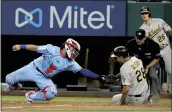  ?? TONY GUTIERREZ — THE ASSOCIATED PRESS ?? Rangers catcher Jose Trevino is unable to tag out the Athletics’ Matt Olson at the plate as umpire Ed Hickox is on the spot to make the call during the eighth inning of Sunday’s game in Arlington, Texas. The A’s lost 7-4.