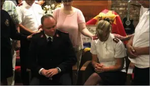  ?? The Sentinel-Record/Max Bryan ?? SEND-OFF: The Salvation Army’s Hot Springs congregati­on prays over outgoing Captains Josh and Ashley Robinett at their farewell service Sunday.