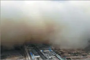  ?? GAO ZHAN / CHINA NEWS SERVICE ?? A sandstorm engulfs Linze county of Zhangye, Gansu province, on Sunday. The sandstorm is moving eastward and hit much of northern China throughout the week.