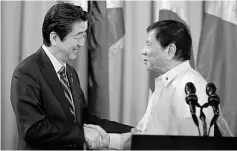  ??  ?? Duterte and visiting Abe shake hands after a joint statement at the presidenti­al palace in Manila, Philippine­s. — Reuters photo