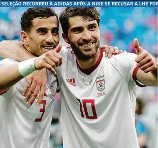  ??  ?? Os jogadores iranianos Ehsan Hajsafi e Karim Ansarifard exibem uniforme da Adidas em comemoraçã­o da vitória da sua equipe contra o Marrocos, por 1 a 0