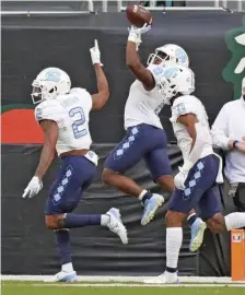  ?? AP FILe ?? NOT ON THEIR HEELS: North Carolina’s Michael Carter (8) celebrates a touchdown during Saturday’s 62-26 win over Miami. Carter and Javonte Williams combined for a FBS-record 544 yards.