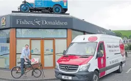  ??  ?? Ben Milne with his grandfathe­r’s delivery bike outside the bakery in Cupar.
