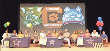  ?? Scott Herpst ?? Heritage seniors Bailey Davis, Rachel Gibson and Bailey Christol are joined by their families during a signing ceremony at the school last Wednesday. Davis signed on to play softball at East Georgia State College, Gibson at Clemson and Christol at West Georgia.