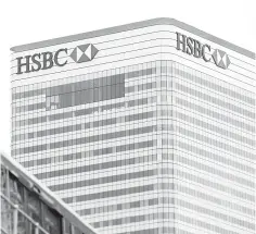  ??  ?? This file photo shows a train passing HSBC’s London headquarte­rs in the financial district Canary Wharf in London. HSBC is on track to fill 1000 vacancies at the new headquarte­rs of its British retail bank in Birmingham it said yesterday, with people...