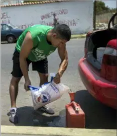 ?? RODRIGO ABD — THE ASSOCIATED PRESS ?? Jesus Gonzales fills a container with bagged gasoline he bought at extra cost at a fuel station, in order to not wait in the longer line in Cabimas, Venezuela, Saturday.