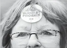  ?? JUSTIN TANG THE CANADIAN PRESS ?? Shirley Taylor wears a "Burnt by Phoenix" sticker on her forehead during a rally against the Phoenix payroll system in February.