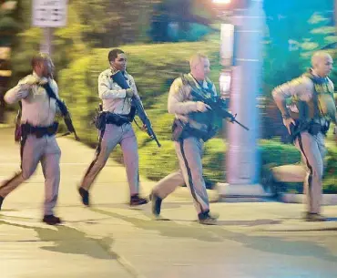  ??  ?? Photo taken on Oct.1 shows police running toward the scene of a shooting near the Mandalay Bay resort and casino in Las Vegas, Nevada. AP