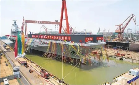  ?? LI GANG XINHUA VIA AP ?? Colored smoke marks the launch ceremony for China’s third aircraft carrier, christened Fujian, at a dry dock in Shanghai on Friday. The vessel is the first such ship to be both designed and built entirely within the country.