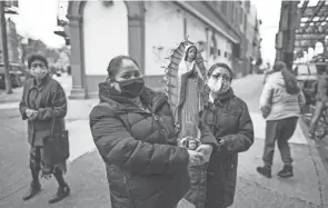  ?? EDUARDO MUNOZ ALVAREZ/AP ?? Mexican migrants carry a statue of the Virgin of Guadalupe in Brooklyn, New York. The Hispanic community in the U.S. has been one of the groups most affected by the COVID-19 pandemic.