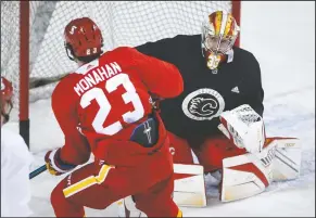  ?? CP PHOTO JEFF MCINTOSH ?? Calgary Flames goalie David Rittich, right, looks on as Sean Monahan shoot wide during a training camp practice in Calgary, Monday.