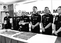  ??  ?? Miri police chief, ACP Khoo (third left), Supt Stanley (second left) and ASP Fikri (third right) display the seized slabs of cannabis during a press conference on Friday.