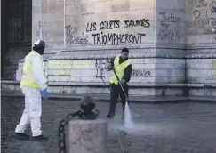  ??  ?? 0 Workers clean up around the graffiti-ridden Arc de Triomphe