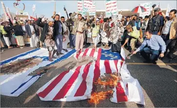  ?? Mohammed Huwais AFP/Getty Images ?? YEMENI supporters of Iranian-backed Houthi rebels burn Israeli and U.S. f lags last month in Sana. The rebels seized control of Yemen’s capital in 2014 with the help of rogue elements of the country’s armed forces.