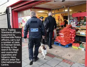  ??  ?? NELC Trading Standards officers, supported by Humberside Police officers, carry out a number of raids in Freeman Street, Grimsby, in the search for illegal and counterfei­t cigarettes and tobacco. Here, officers enter the Internatio­nal Food Centre.