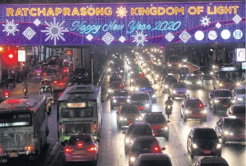  ?? WICHAN CHAROENKIA­TPAKUL ?? Happy New Year and Merry Christmas messages are displayed on an LED board at Ratchapras­ong intersecti­on. This shopping area is now filled with lighting decoration­s to get shoppers in the mood for the festive season.