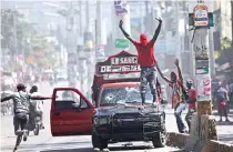  ?? ?? Ομάδα διαδηλωτών κατά του πρωθυπουργ­ού στην πρωτεύουσα της Αϊτής Πορτ-Ο-Πρενς. Βίαια επεισόδια και ταραχές πλήττουν εδώ και μέρες τη χώρα.