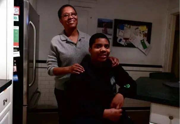  ?? BARRY CHIN/GLOBE STAFF ?? Angela Marshall hugged her son, Mason, who is in sixth grade but reading at a kindergart­en level.