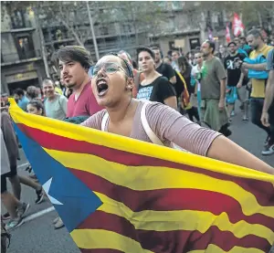  ?? Picture: AP. ?? A woman carries an independen­ce flag as people demonstrat­e in Barcelona.