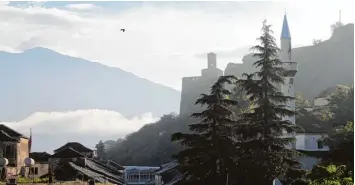  ?? ?? Die Stadt Gjirokastr­a liegt südlich in den Bergen Albaniens. Bekannt ist dieser Ort für seine schöne Altstadt (im Bild unten), die steinernen Dachplatte­n auf den Häusern und die Festung, die über der Stadt liegt.