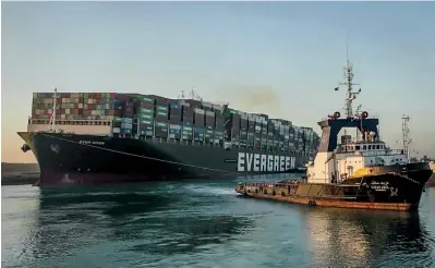  ?? The Associated Press ?? ■ In this photo released by Suez Canal Authority, the Ever Given, a Panama-flagged cargo ship, is pulled by one of the Suez Canal tugboats on Monday in the Suez Canal, Egypt. Engineers on Monday “partially refloated “the colossal container ship that continues to block traffic through the Suez Canal, authoritie­s said, without providing further details about when the vessel would be set free.