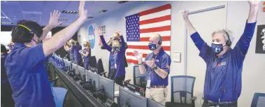  ?? BILL INGALLS / NASA / AFP VIA GETTY IMAGES ?? Members of NASA's Perseveran­ce rover team cheer Thursday in the mission control room at the Jet Propulsion Laboratory in Pasadena, Calif., after receiving confirmati­on the spacecraft successful­ly touched down on Mars.