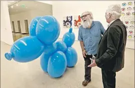  ?? Mel Melcon Los Angeles Times ?? IN BRIGHTER days at the Marciano Art Foundation, Paul McCarthy, left, talks with collector Maurice Marciano next to McCarthy’s “White Snow, Balloon Dog.”