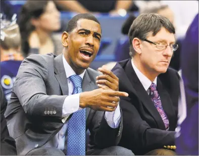  ?? Fred Beckham / Associated Press ?? Former UConn coach Kevin Ollie and associate head coach Glenn Miller watch a 2013 game in Hartford. Ollie has filed a lawsuit against Miller, contending that Miller slandered him in comments to the NCAA.