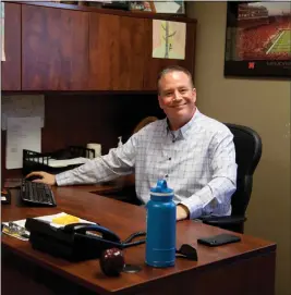  ?? Donnis Hueftle-Bullock ?? Above, Sid Fessler sits at his office desk with his bottle of water and healthy afternoon snack of an apple handy.