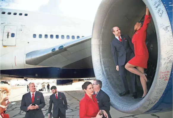  ?? DAVID WALLACE/ARIZONA REPUBLIC ?? At the Pinal Airpark in Marana, Ariz., Delta flight attendants Kirk Wise and Chesed Gomez have fun inside the turbine of Delta’s last 747.
