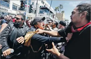  ?? Luis Sinco Los Angeles Times ?? THE PROTESTS against racial injustice also came to Huntington Beach after George Floyd’s killing, drawing pro-Trump counterpro­testers too. A woman tried to defuse a scuff le.