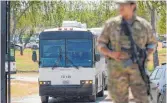  ?? FOTO: ERIC GAY/DPA ?? Ein Nationalga­rdist an einem Tor des Grenzzauns im texanische­n Del Rio. Der Bus fährt haitianisc­he Migranten zum Flughafen, sie müssen zurück in ihre Heimat.