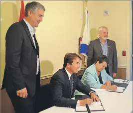  ??                                                      ?? Premier Stephen McNeil, left, and Kings-South MLA Keith Irving, right, watch as Kings-Hants MP and treasury board president Scott Brison and Joanne Bernard, Community Services Minister and Minister responsibl­e for Housing Nova Scotia, sign a...