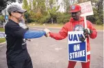  ?? MATT ROURKE/ASSOCIATED PRESS ?? Picketing United Auto Workers Richard Rivera, left, and Will Myatt, in Langhorne, Pennsylvan­ia, react Wednesday to news of a tentative contract agreement with General Motors.