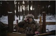  ?? (AP/Daniel Cole) ?? A Ukrainian soldier keeps watch for Belarusian troop activity Wednesday along the 650-mile frontier of marsh and woodland separating the countries.