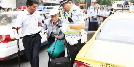  ??  ?? A police officer and volunteer driver assist him to the examinatio­n hall in Nanjing in eastern China.