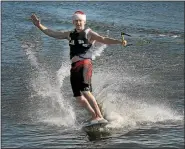  ?? GENE WALSH — DIGITAL FIRST MEDIA ?? Peter Bostock waves to onlookers as he water-skis along the Schuylkill River during the annual Port Indian Ski Freeze Jan. 1, 2017.