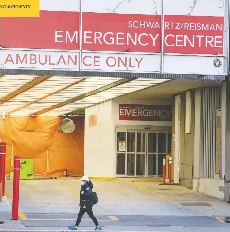  ?? PETER J THOMPSON / NATIONAL POST ?? A woman wearing a protective mask walks past Mount Sinai Hospital’s Emergency Centre in Toronto on Wednesday.