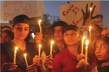  ?? — AP ?? Indians hold candles to condemn the brutal gangrape of a woman on December 16, 2012 in New Delhi